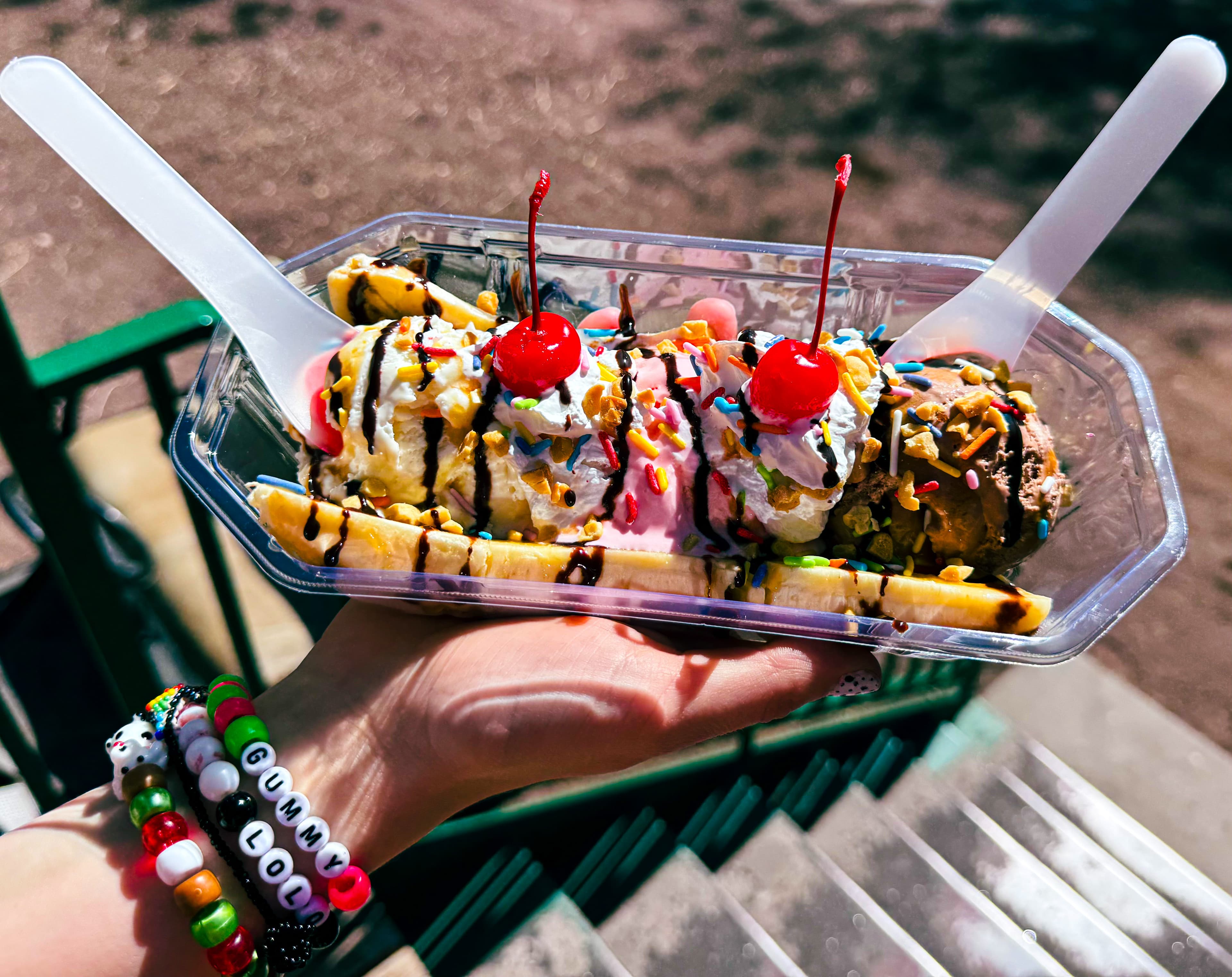 A Banana Split for two — three scoops, bananas, cherries, sprinkles, and chocolate drizzle in a clear tray
