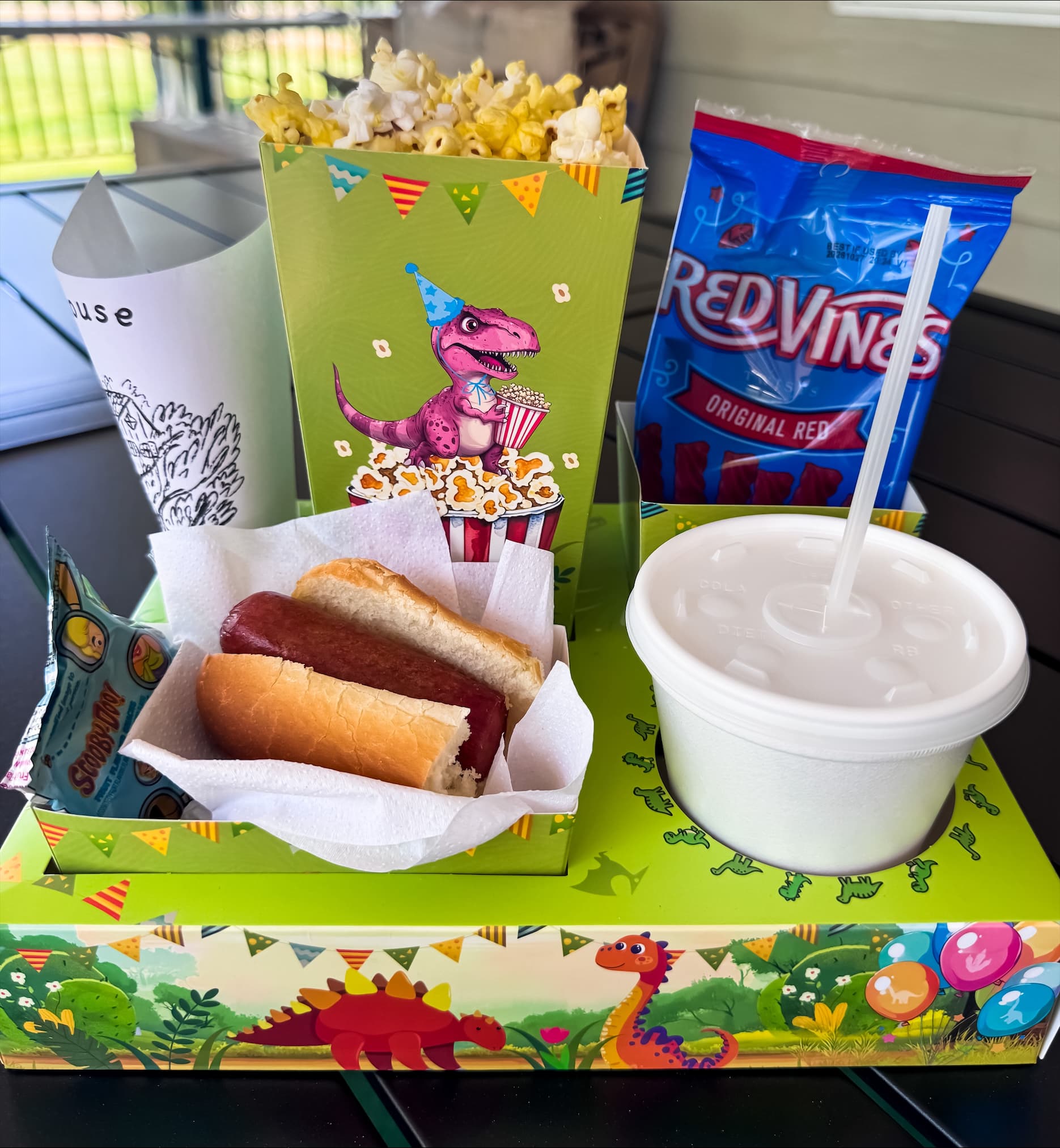 Dinosaur-themed kids combo box with a Nathan's hot dog, popcorn, candy, ice cream, and a drink